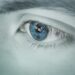 Detailed close-up of a blue eye showing a reflection, emphasizing uniqueness. szem